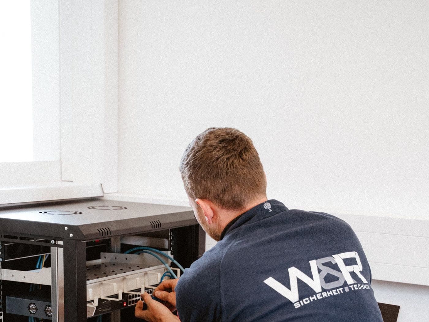 Techniker von W&R Sicherheitstechnik bei der Verkabelung eines Netzwerk-Racks